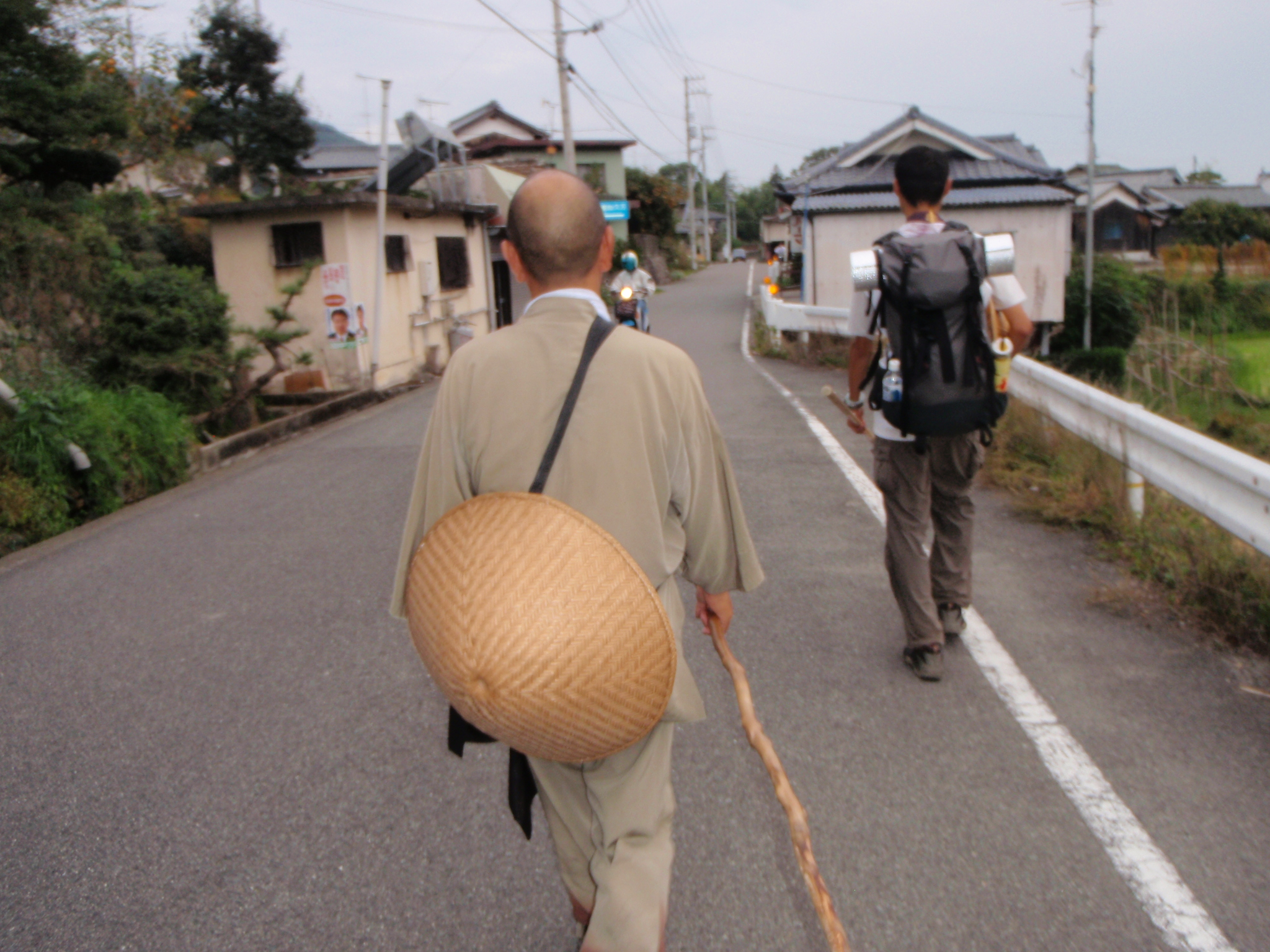 笠を背負い、遍路道を歩く旅人