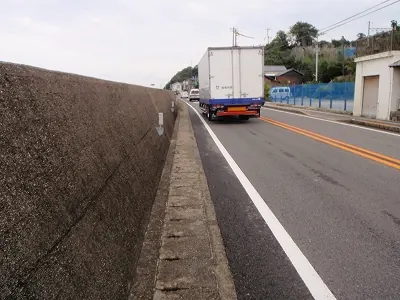 トラックに吹き飛ばされそうになる道